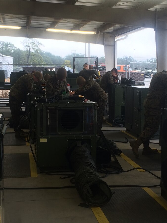 Marines working on a pump and water purifier.