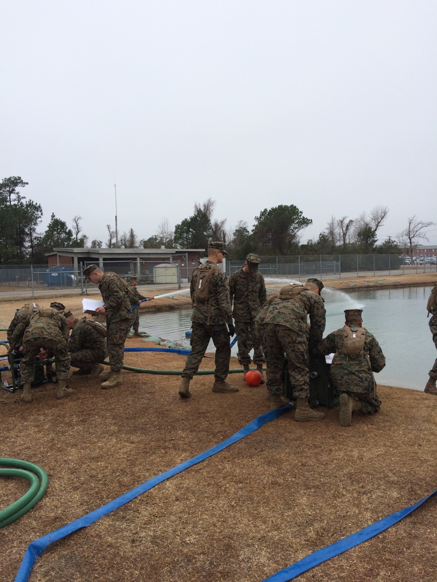 Marines working on a pump and water purifier.