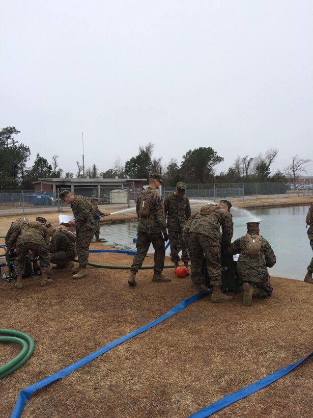 Marines working on a pump and water purifier.