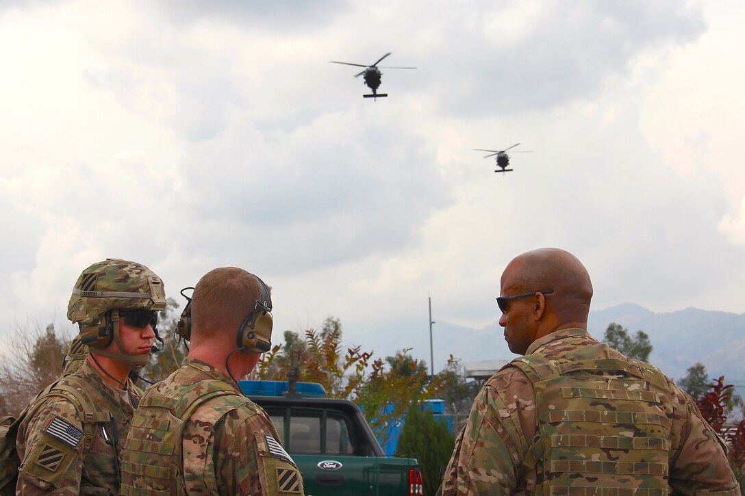 U.S. Army 1st Lt. Steven Sanders, left, U.S. Army Brig. Gen. Christopher Bentley, center, commander of Train, Advise, Assist Command East, and U.S. Army Col. Gregory Stokes, right, commander of the Police Advisory Team assigned to the command, observe inbound UH-60 Black Hawk helicopters at the end of their advising visit to the Afghan National Civil Order Police's 2nd Brigade headquarters in Nangarhar province, Afghanistan, March 3, 2015.