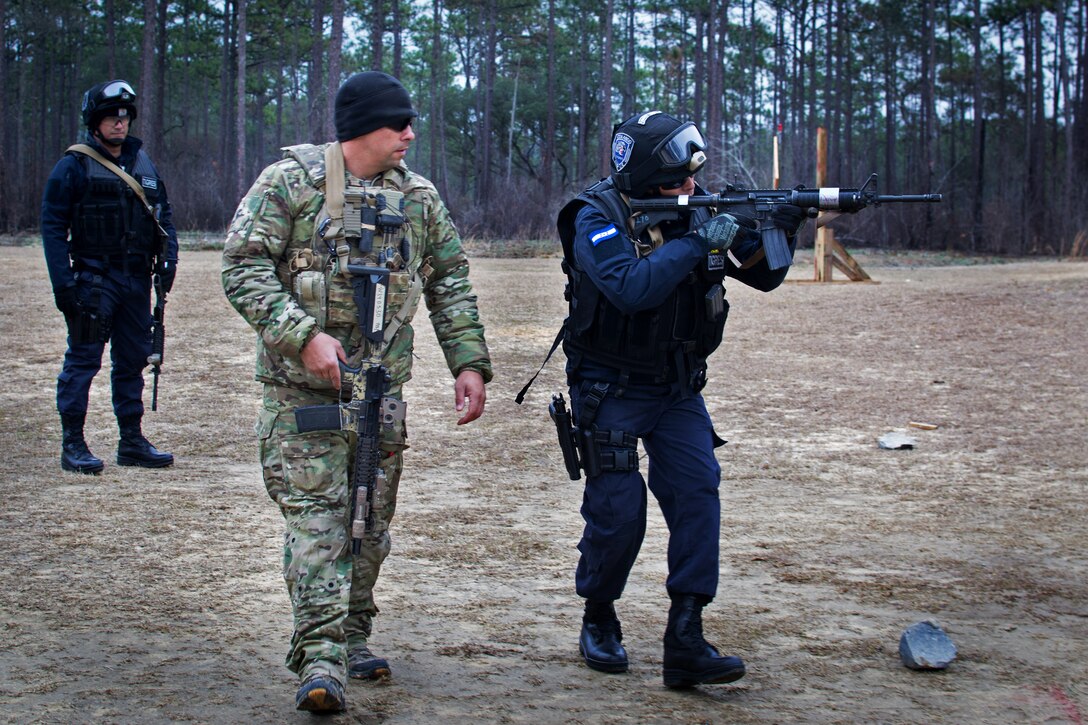 An Army Green Beret, center, mentors a member of the Honduran commandos during a shooting drill at a range on Eglin Air Force Base, Fla., Feb. 24, 2015.