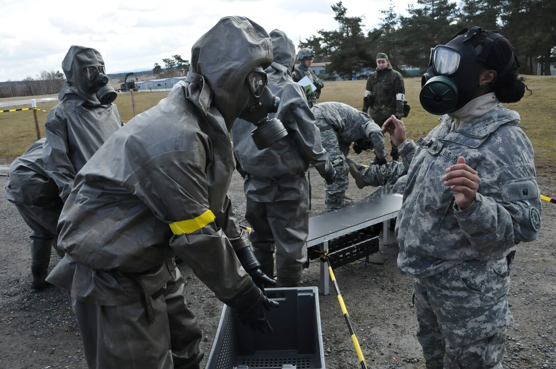U.S. soldiers put on masks and special clothing for chemical, biological, radiological and nuclear validation and certification training, alongside German soldiers at Grafenwoehr Training Area near Rose Barracks, Germany, March 4, 2015. The soldiers are assigned to Headquarters and Headquarters Troop, Regimental Engineer Squadron.