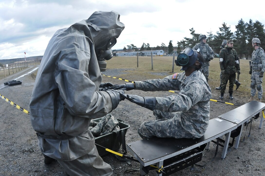 U.S. soldiers put on gloves for chemical, biological, radiological and nuclear validation and certification training alongside German soldiers at Grafenwoehr Training Area near Rose Barracks, Germany, March 4, 2015.
