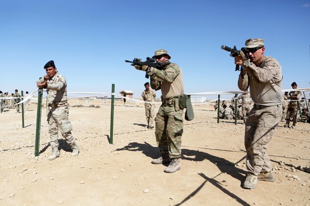 U.S. Marines and coalition forces with Task Force Al Asad teach Iraqi soldiers how to enter rooms using tape houses during Military Operations on Urban Terrain training aboard Al Asad Air Base, Iraq, Feb. 14-16, 2015. The three-day training period utilized different MOUT facilities in order to teach Iraqi soldiers basic room clearing techniques, how to move across linear danger areas as a squad, and the proper way to maneuver through a building in fire teams. (U.S. Marine Corps photo by Cpl. Tony Simmons/RELEASED)