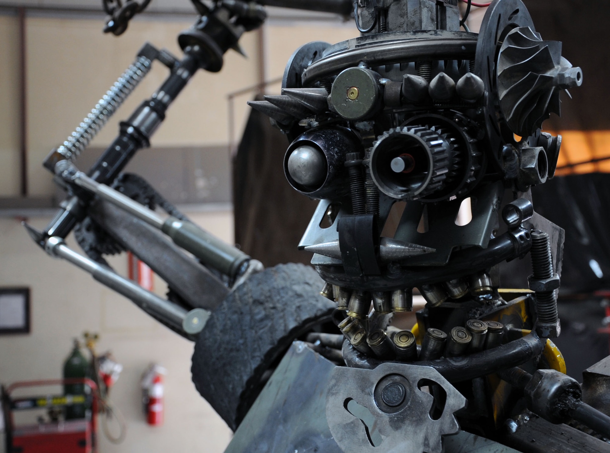 "Ironman" leers menacingly at onlookers while on display at the 386th Expeditionary Maintenance Squadron Combat Metals Flight. More than 200 pieces of scrap went into the sculpture, which took the flight two weeks to complete. (U.S. Air Force photo by Master Sgt. Eric Petosky)