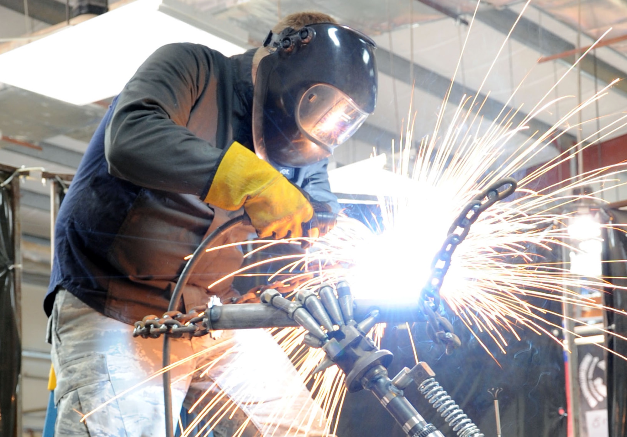 Tech. Sgt. Patrick Pittman, 386th Expeditionary Maintenance Squadron Combat Metals Flight machinist, puts the finishing welds on his scrap metal sculpture. Pittman and his team used more than 200 pieces of scrap metal to create the 7-foot sculpture dubbed "Ironman." (U.S. Air Force photo by Master Sgt. Eric Petosky)