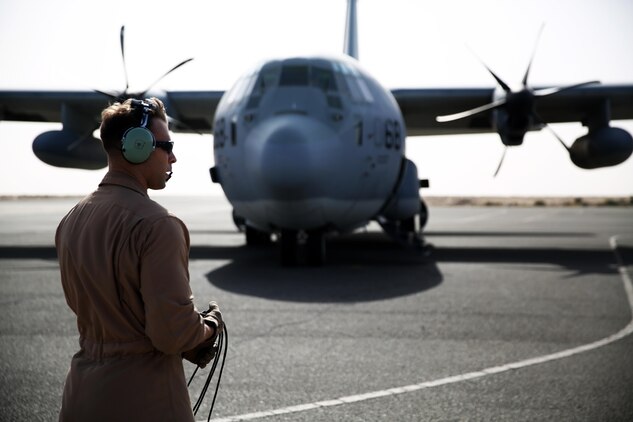 A U.S. Marine aircraft crewman with Marine Aerial Refueler Transport Squadron 352, Special Purpose Marine Air Ground Task Force – Crisis Response – Central Command, performs pre-flight checks on a KC-130J Hercules before takeoff in the Central Command area of operations, Feb. 23, 2015. The Marines, sailors and aircraft with VMGR 352 support SPMAGTF – CR – CC by transporting supplies, equipment, and personnel to various locations in the region.  (U.S. Marine Corps photo by Cpl. Carson Gramley/RELEASED)
