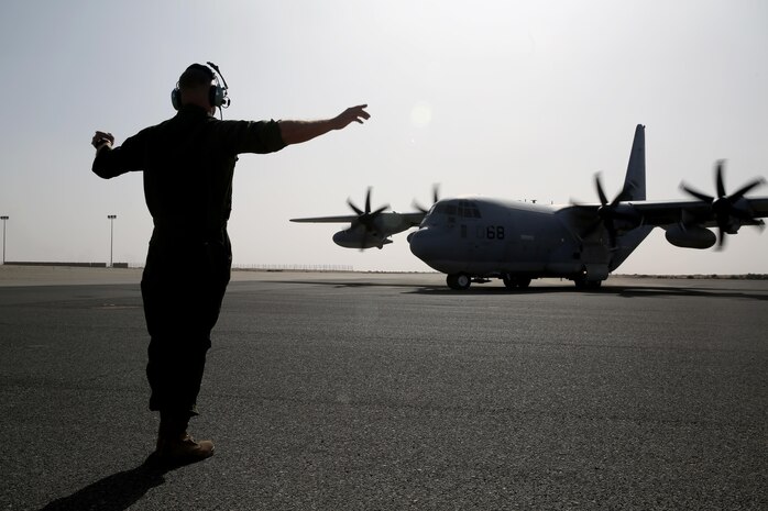 A U.S. Marine with Marine Aerial Refueler Transport Squadron 352, Special Purpose Marine Air Ground Task Force – Crisis Response – Central Command, directs a KC-130J Hercules to the runway before takeoff in the Central Command area of operations, Feb. 23, 2015. The Marines, sailors and aircraft with VMGR 352 support SPMAGTF – CR – CC by transporting supplies, equipment, and personnel to various locations in the region.  (U.S. Marine Corps photo by Cpl. Carson Gramley/RELEASED)