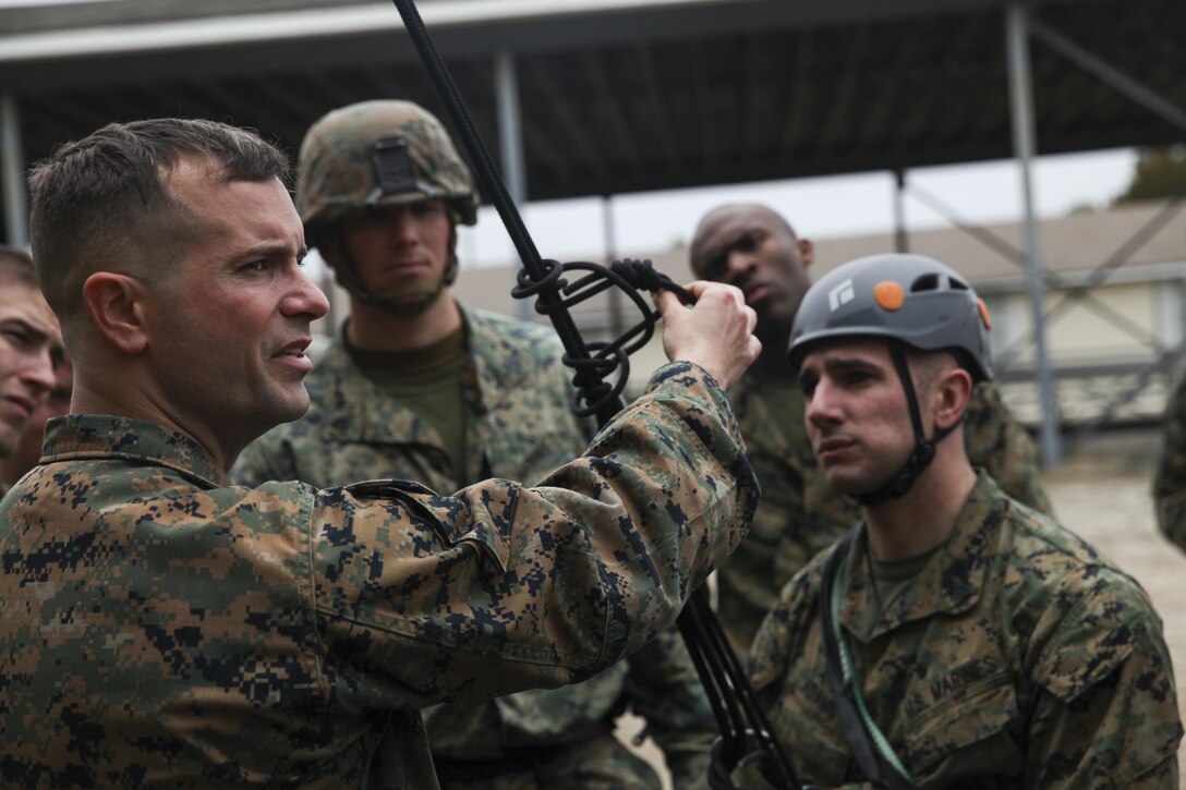 Staff Sgt. Matthew Francis instructs his students on proper knot tying techniques during the helicopter ropes suspension techniques course taught by Expeditionary Operations Training Group March 3, 2015, at Stone Bay, Marine Corps Base Camp Lejeune, N.C. The 10-day course teaches Marines to become subject-matter experts at controlling fast-rope or rappelling exercises. Units with HRST capabilities make it possible to insert or extract Marines from an area where landing an aircraft would be impossible. (Marine Corps photo by Cpl. Michelle Reif/released)