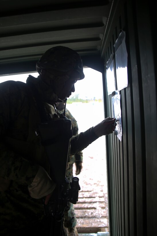 Lance Cpl. Henry D. Washington, a guard force member for a 2nd Marine Logistics Group command post exercise, ensures the authenticity of individuals coming into the command operations center by checking identification cards during the CPX aboard Marine Corps Base Camp Lejeune, N.C., Feb. 24, 2015. The purpose of the guard force is to guarantee no one passes through to the command operations center without proper authority or an escort. (U.S. Marine Corps Photo by Cpl. Chelsea D. Toombs/Released)