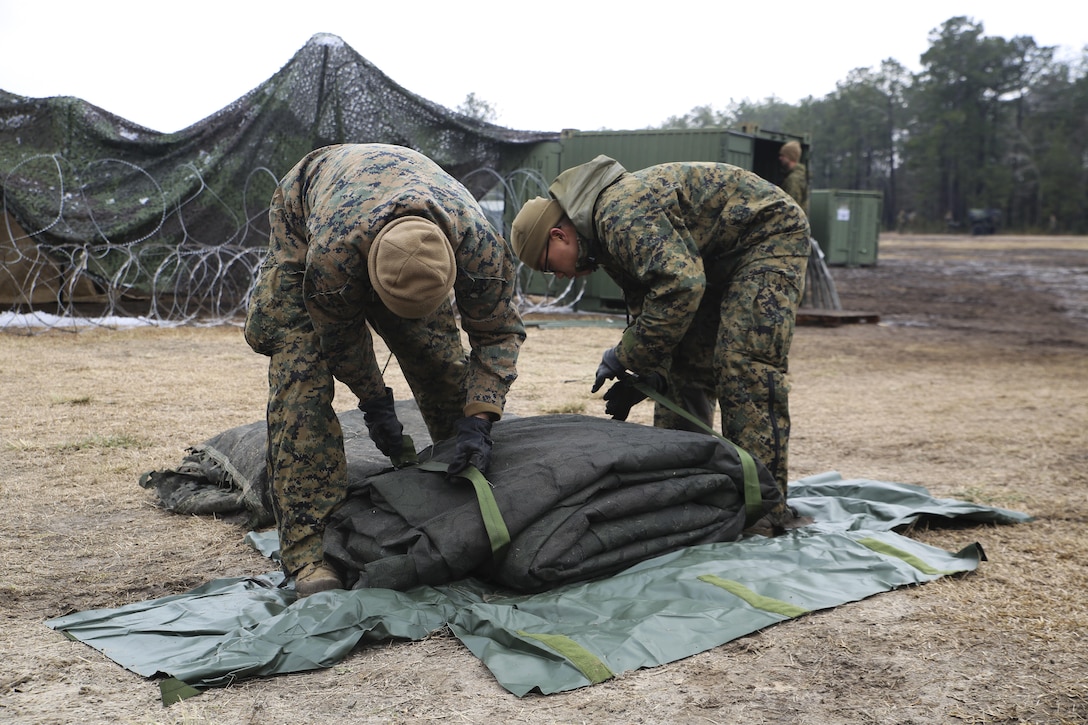 Sergeant Ezequiel M. Herrada (left), supply administrative chief for Headquarters Regiment, and Cpl. Won Gyu Lee (right), supply administrator for Headquarters Regiment, pack camouflage netting during a command post exercise aboard Marine Corps Base Camp Lejeune, N.C., Feb. 25, 2015. The purpose of the CPX was to ensure the unit’s readiness and identify areas in need of improvement. (U.S. Marine Corps Photo by Chelsea D. Toombs/Released)