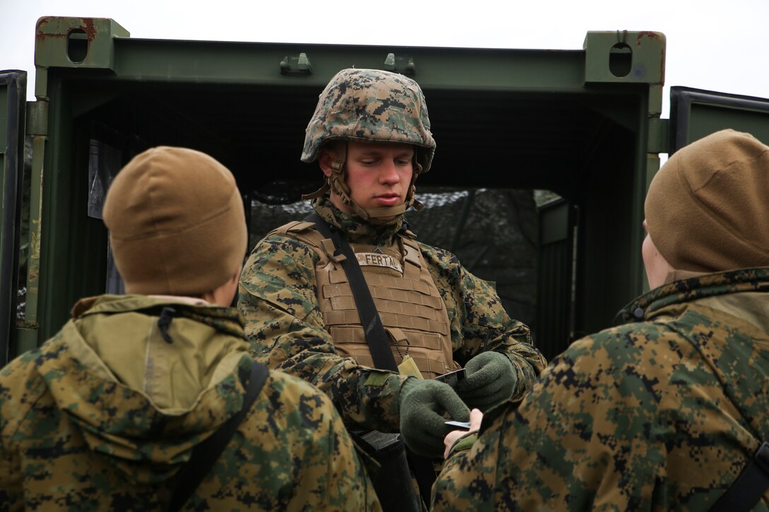 A member of the guard force for the 2nd Marine Logistics Group command post exercise ensures the validity of individuals coming into the command operations center by checking identification cards during the CPX aboard Marine Corps Base Camp Lejeune, N.C., Feb. 25, 2015. The purpose of the guard force is to guarantee no one passes through to the command operations center without proper authority or an escort. (U.S. Marine Corps Photo by Cpl. Chelsea D. Toombs/Released)