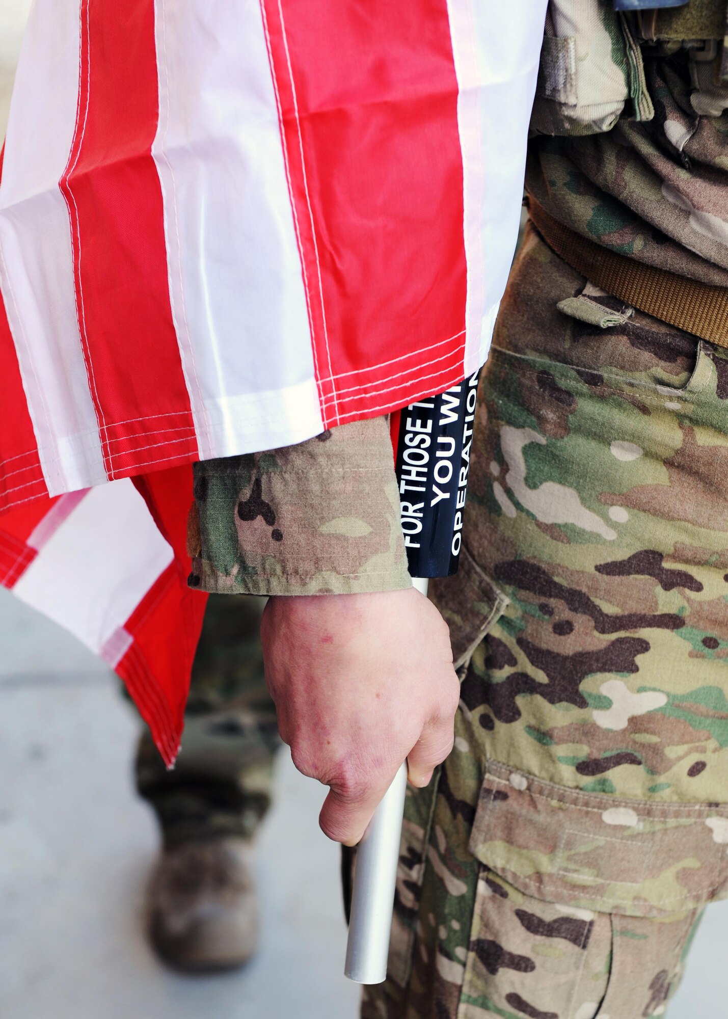 A U.S. Air Force Airman assigned to the 83rd Expeditionary Rescue Squadron holds a U.S. flag bearing the names of seven special operators who were killed March 4, 2002 during Operation Anaconda: U.S. Air Force Senior Airman Jason Cunningham, U.S. Army Cpl. Matthew Commons, U.S. Army Spc. Marc Anderson, U.S. Army Sgt. Phillip Svitak, U.S. Army Sgt. Bradley Crose, U.S. Navy Petty Officer 1st Class Neil Roberts and U.S. Air Force Tech. Sgt. John Chapman, March 3, 2015 at Bagram Airfield, Afghanistan. Servicemembers from all branches conducted a 24-hour vigil run and a retreat ceremony to honor the 13th anniversary of their deaths and pay homage to a legacy of heroism. (U.S. Air Force photo by Staff Sgt. Whitney Amstutz/released)