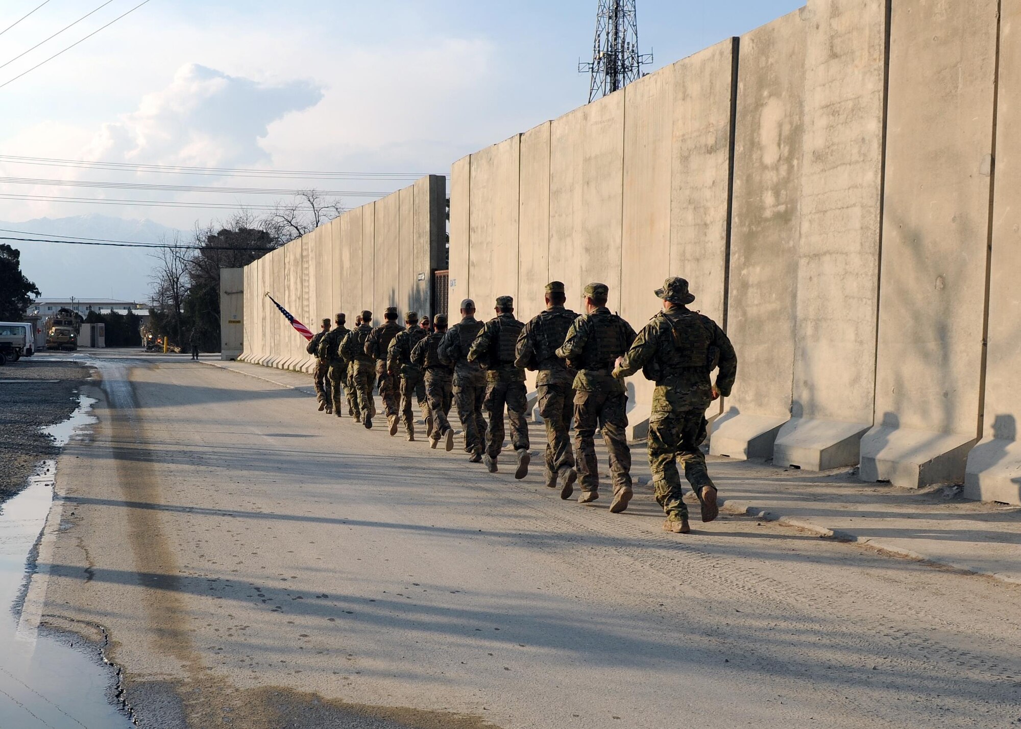 A multiservice formation of special operators runs with a U.S. flag bearing the names of seven special operators who were killed March 4, 2002 during Operation Anaconda: U.S. Air Force Senior Airman Jason Cunningham, U.S. Army Cpl. Matthew Commons, U.S. Army Spc. Marc Anderson, U.S. Army Sgt. Phillip Svitak, U.S. Army Sgt. Bradley Crose, U.S. Navy Petty Officer 1st Class Neil Roberts and U.S. Air Force Tech. Sgt. John Chapman, March 3, 2015 at Bagram Airfield, Afghanistan. Servicemembers from all branches conducted a 24-hour vigil run and a retreat ceremony to honor the 13th anniversary of their deaths and pay homage to a legacy of heroism. (U.S. Air Force photo by Staff Sgt. Whitney Amstutz/released)