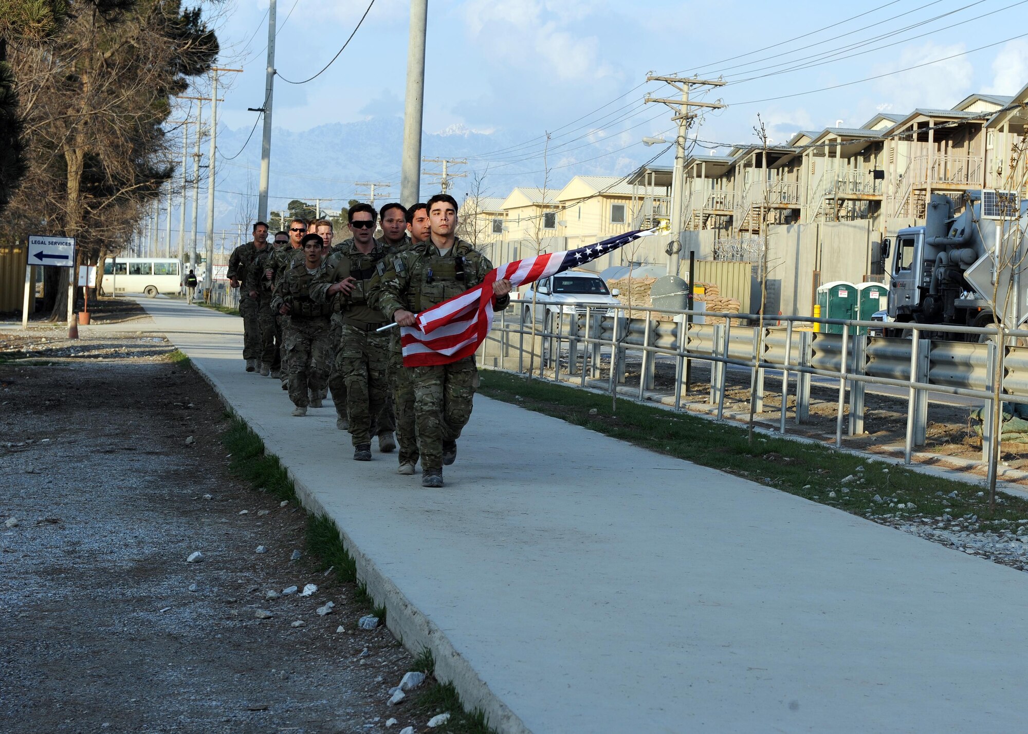 A multiservice formation of special operators runs with a U.S. flag bearing the names of seven special operators who were killed March 4, 2002 during Operation Anaconda: U.S. Air Force Senior Airman Jason Cunningham, U.S. Army Cpl. Matthew Commons, U.S. Army Spc. Marc Anderson, U.S. Army Sgt. Phillip Svitak, U.S. Army Sgt. Bradley Crose, U.S. Navy Petty Officer 1st Class Neil Roberts and U.S. Air Force Tech. Sgt. John Chapman, March 3, 2015 at Bagram Airfield, Afghanistan. Servicemembers from all branches conducted a 24-hour vigil run and a retreat ceremony to honor the 13th anniversary of their deaths and pay homage to a legacy of heroism. (U.S. Air Force photo by Staff Sgt. Whitney Amstutz/released)