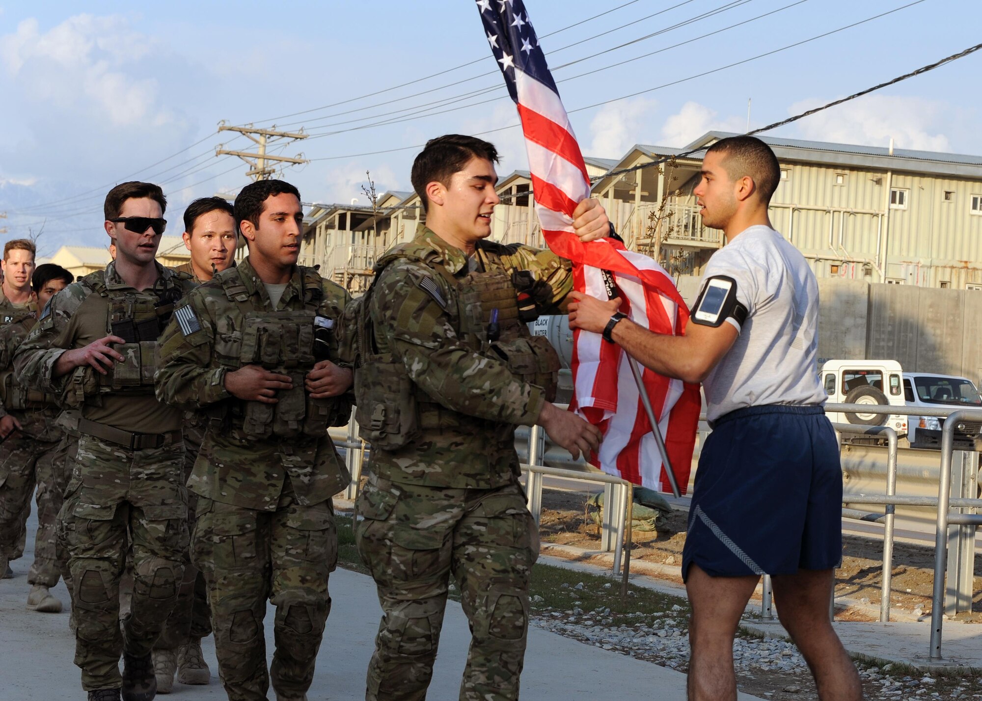 A multiservice formation of special operators passes a U.S. flag bearing the names of seven special operators who were killed March 4, 2002 during Operation Anaconda: U.S. Air Force Senior Airman Jason Cunningham, U.S. Army Cpl. Matthew Commons, U.S. Army Spc. Marc Anderson, U.S. Army Sgt. Phillip Svitak, U.S. Army Sgt. Bradley Crose, U.S. Navy Petty Officer 1st Class Neil Roberts and U.S. Air Force Tech. Sgt. John Chapman, March 3, 2015 at Bagram Airfield, Afghanistan. Servicemembers from all branches conducted a 24-hour vigil run and a retreat ceremony to honor the 13th anniversary of their deaths and pay homage to a legacy of heroism. (U.S. Air Force photo by Staff Sgt. Whitney Amstutz/released)