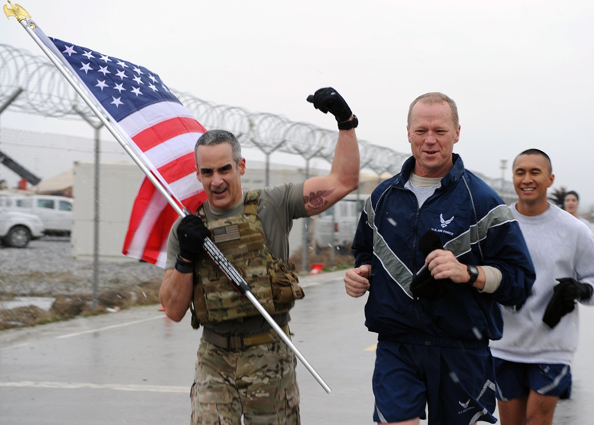 U.S. Air Force Brig. Gen. Mark Kelly, 455th Air Expeditionary Wing commander, and U.S. Air Force Chief Master Sgt. Ramon "CZ" Colon-Lopez, Air Force Central Command command chief, run with a flag bearing the names of seven special operators who were killed March 4, 2002 during Operation Anaconda: U.S. Air Force Senior Airman Jason Cunningham, U.S. Army Cpl. Matthew Commons, U.S. Army Spc. Marc Anderson, U.S. Army Sgt. Phillip Svitak, U.S. Army Sgt. Bradley Crose, U.S. Navy Petty Officer 1st Class Neil Roberts and U.S. Air Force Tech. Sgt. John Chapman, March 4, 2015 at Bagram Airfield, Afghanistan. Servicemembers from all branches conducted a 24-hour vigil run and a retreat ceremony to honor the 13th anniversary of their deaths and pay homage to a legacy of heroism. (U.S. Air Force photo by Staff Sgt. Whitney Amstutz/released)
