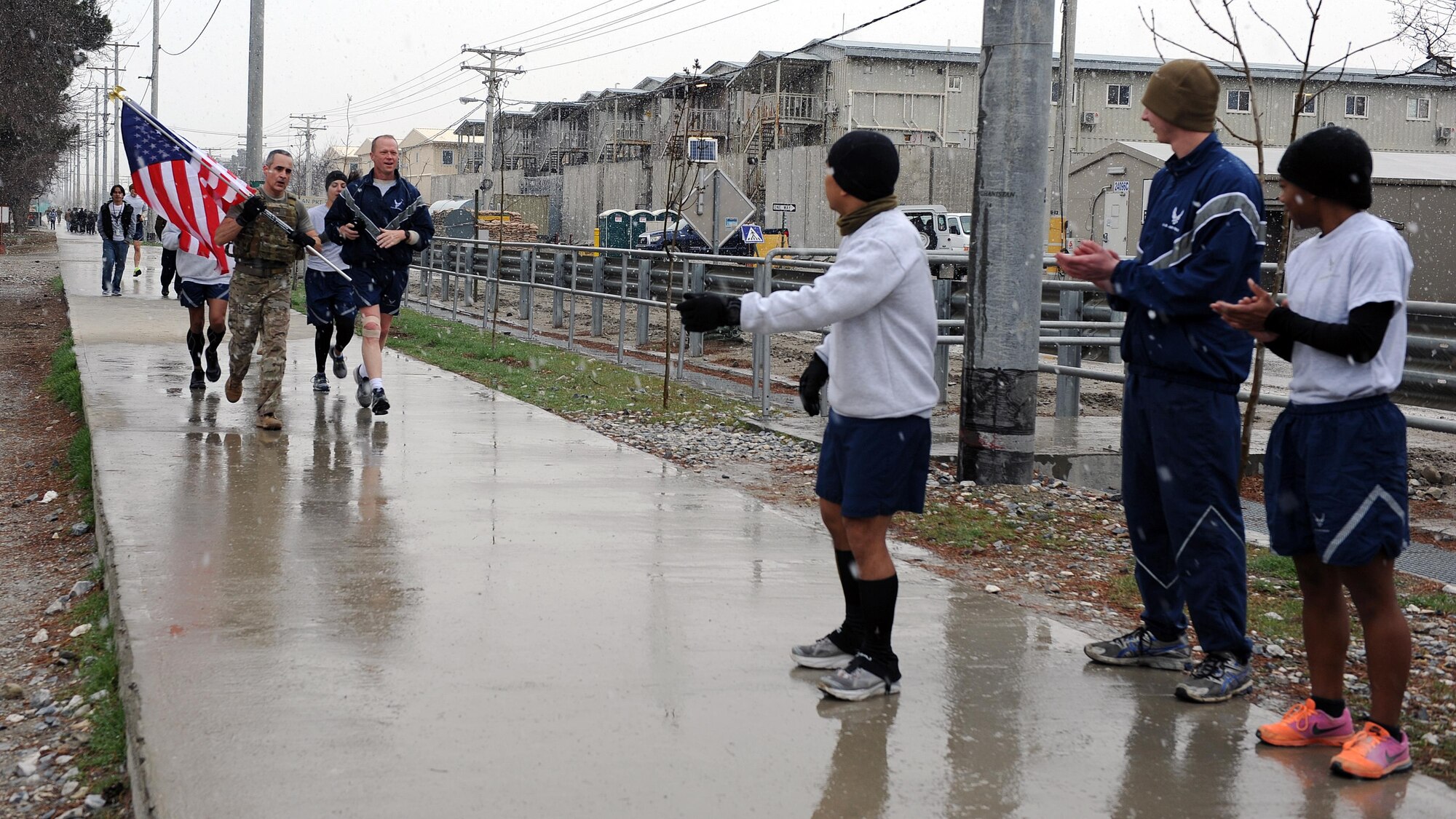 U.S. Air Force Brig. Gen. Mark Kelly, 455th Air Expeditionary Wing commander, and U.S. Air Force Chief Master Sgt. Ramon "CZ" Colon-Lopez, Air Force Central Command command chief, run with a flag bearing the names of seven special operators who were killed March 4, 2002 during Operation Anaconda: U.S. Air Force Senior Airman Jason Cunningham, U.S. Army Cpl. Matthew Commons, U.S. Army Spc. Marc Anderson, U.S. Army Sgt. Phillip Svitak, U.S. Army Sgt. Bradley Crose, U.S. Navy Petty Officer 1st Class Neil Roberts and U.S. Air Force Tech. Sgt. John Chapman, March 4, 2015 at Bagram Airfield, Afghanistan. Servicemembers from all branches conducted a 24-hour vigil run and a retreat ceremony to honor the 13th anniversary of their deaths and pay homage to a legacy of heroism. (U.S. Air Force photo by Staff Sgt. Whitney Amstutz/released)