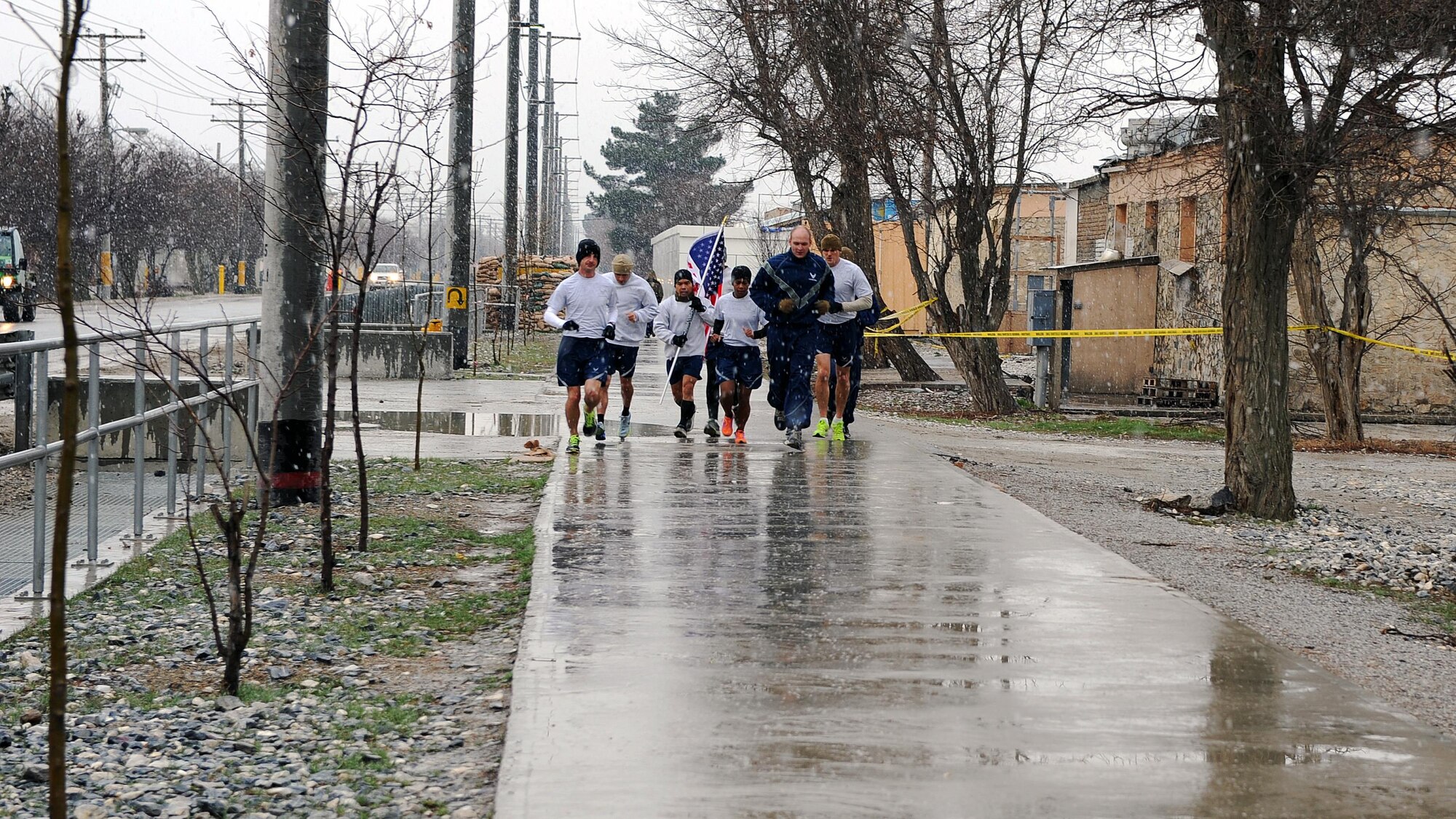 U.S. Air Force Airmen run with a U.S. flag bearing the names of seven special operators who were killed March 4, 2002 during Operation Anaconda: U.S. Air Force Senior Airman Jason Cunningham, U.S. Army Cpl. Matthew Commons, U.S. Army Spc. Marc Anderson, U.S. Army Sgt. Phillip Svitak, U.S. Army Sgt. Bradley Crose, U.S. Navy Petty Officer 1st Class Neil Roberts and U.S. Air Force Tech. Sgt. John Chapman, March 4, 2015 at Bagram Airfield, Afghanistan. Servicemembers from all branches conducted a 24-hour vigil run and a retreat ceremony to honor the 13th anniversary of their deaths and pay homage to a legacy of heroism. (U.S. Air Force photo by Staff Sgt. Whitney Amstutz/released)