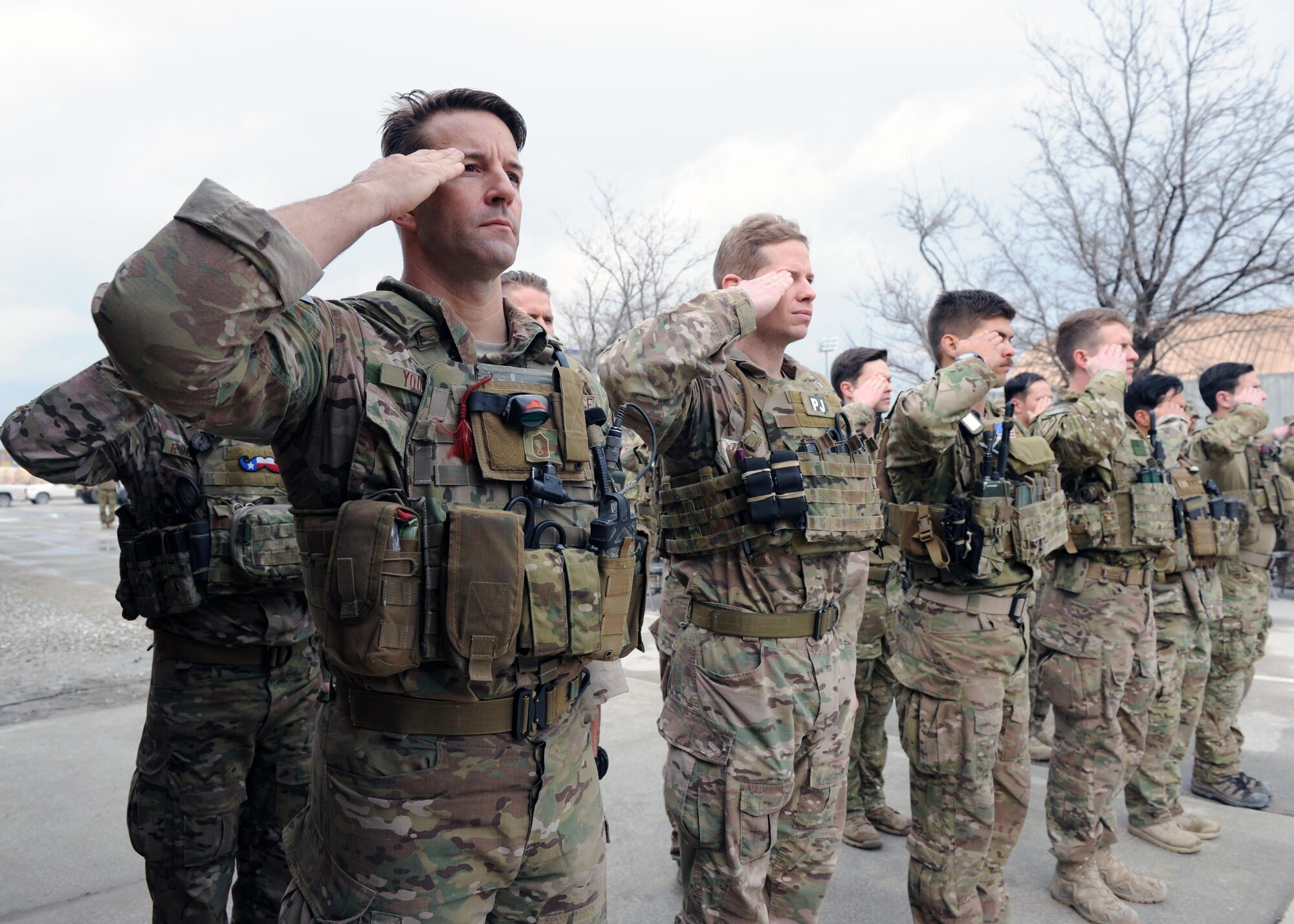 A multiservice formation of special operators render a salute as the U.S. flag is lowered during a retreat ceremony honoring special operators who were killed March 4, 2002 during Operation Anaconda: U.S. Air Force Senior Airman Jason Cunningham, U.S. Army Cpl. Matthew Commons, U.S. Army Spc. Marc Anderson, U.S. Army Sgt. Phillip Svitak, U.S. Army Sgt. Bradley Crose, U.S. Navy Petty Officer 1st Class Neil Roberts and U.S. Air Force Tech. Sgt. John Chapman, March 4, 2015 at Bagram Airfield, Afghanistan. Servicemembers from all branches conducted a 24-hour vigil run and a retreat ceremony to honor the 13th anniversary of their deaths and pay homage to a legacy of heroism. (U.S. Air Force photo by Staff Sgt. Whitney Amstutz/released)