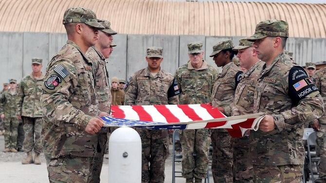 Airmen prepare to fold the American flag March 4, 2015, at Bagram Airfield, Afghanistan, during a retreat ceremony honoring special operators who were killed March 4, 2002, during Operation Anaconda. The lives lost during the operation included Air Force Senior Airman Jason Cunningham, Army Cpl. Matthew Commons, Army Spc. Marc Anderson, Army Sgt. Phillip Svitak, Army Sgt. Bradley Crose, Navy Petty Officer 1st Class Neil Roberts and Air Force Tech. Sgt. John Chapman. Service members from all branches conducted a 24-hour vigil run and a retreat ceremony to honor the 13th anniversary of their deaths and pay homage to a legacy of heroism. (U.S. Air Force photo/Staff Sgt. Whitney Amstutz)