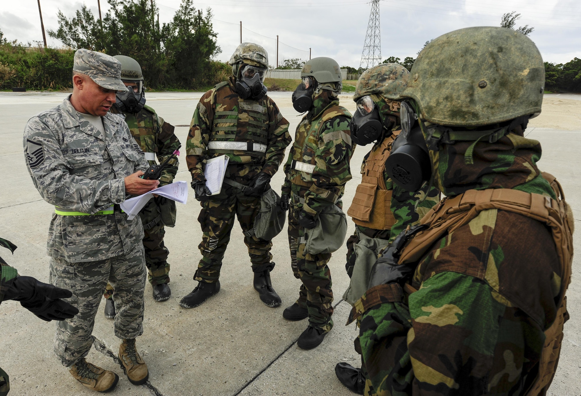 Master Sgt. Richard Holguin speaks to civil engineer Airmen and Marines Feb. 26, 2015, at Kadena Air Base, Japan. Holguin acted as the wing inspection team lead and explained the differences in practice between a training exercise and a real-world scenario. Joint forces from the 172nd and 171st Engineering Companies and 18th Civil Engineer Squadron worked together to repair a damaged runway in response to a simulated air attack. Holguin is the 718th CES Engineering Flight superintendent. (U.S. Air Force photo/Airman 1st Class John Linzmeier)