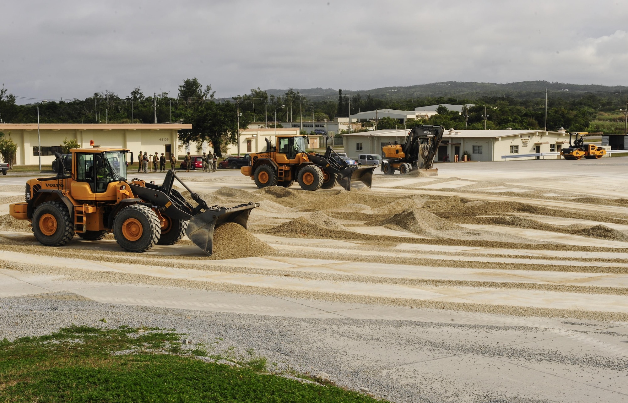 Loaders, operated by 18th Civil Engineer Group Airmen, level out a 50-foot crater on a mock runway Feb. 26, 2015, at Kadena Air Base, Japan. Marines from the 172nd and 171st Engineering Companies participated in a joint airfield damage and repair contingency exercise to learn how civil engineer Airmen respond to airfield damage and to strengthen joint capabilities of reestablishing an operational runway. (U.S. Air Force photo/Airman 1st Class John Linzmeier)