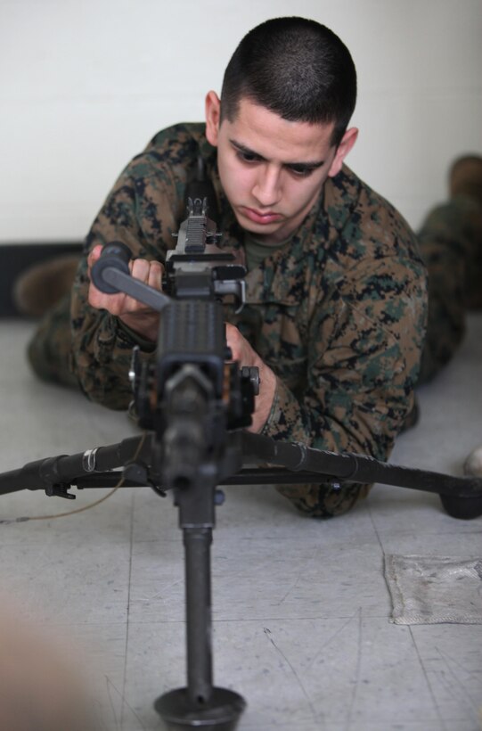 Lance Cpl. Jesus Garibay pulls the charging handle of an M-240B machine gun during a class at Marine Corps Air Station Cherry Point, N.C., Feb. 26, 2015, in preparation for possible future operations.  Garibay is a supply administration and operation specialist with Marine Wing Support Squadron 271. 