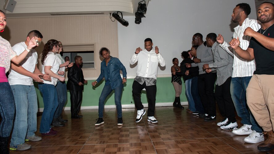 Wolf Pack Airmen dance down a soul train line during a musical and masquerade event held at the Loring Club at Kunsan Air Base, Republic of Korea, Feb. 28, 2015. The event was in celebration of 100 years of music influenced by African American culture, as part of African American/Black History Month at Kunsan. (U.S. Air Force photo by Senior Airman Taylor Curry/Released) 
