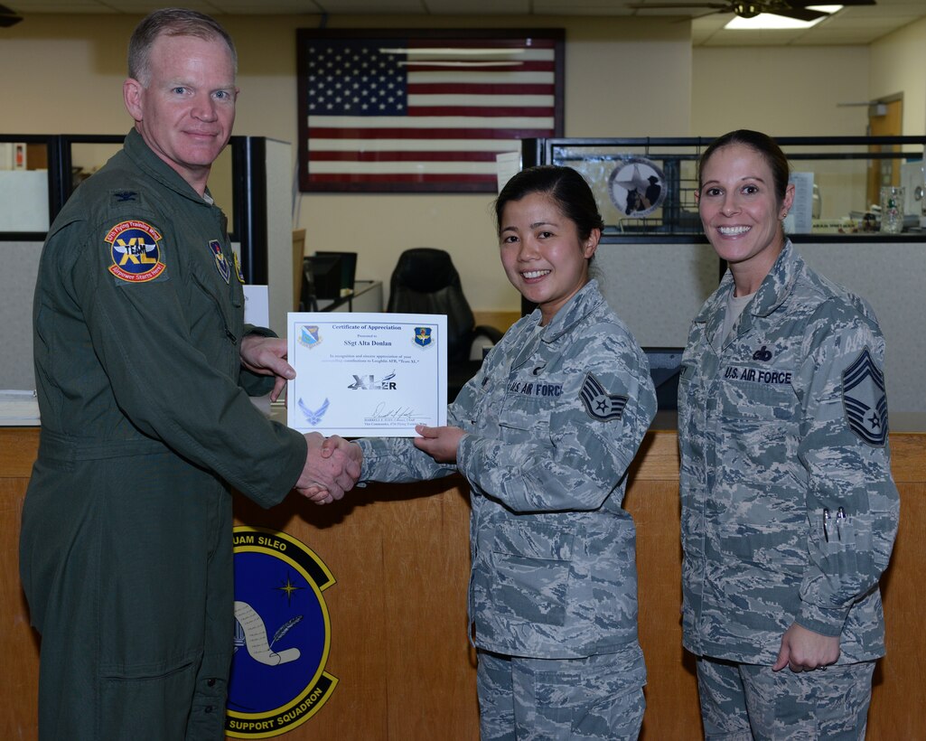 Staff Sgt. Alta Donlan, center, 47th Force Support Squadron NCO in-charge of Human Resource systems, poses with Col. Darrell Judy, left, 47th Flying Training Wing vice commander and Chief Master Sgt. Patricia Hickey, right, 47th Mission Support Group command chief, after accepting the XLer of the week award here March 4, 2015. The XLer is a weekly award chosen by wing leadership and is presented to those who consistently make outstanding contributions to their unit and Laughlin. (U.S. Air Force photo by Airman 1st Class Jimmie D. Pike)(Released)
