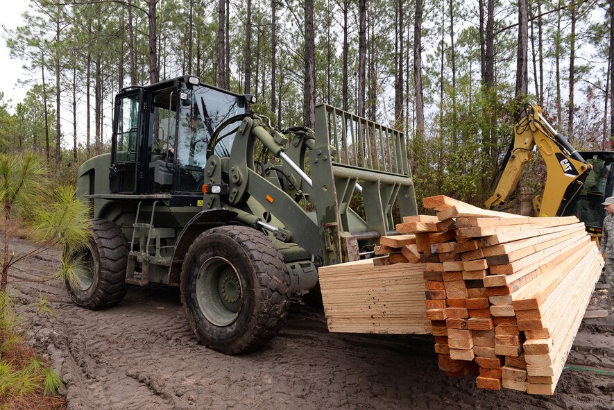 U.S. Air Force Staff Sgt. Melvin Hartley, 23d Civil Engineer Squadron heating, ventilating and air conditioning craftsman, transports wooden planks to build a command post Feb. 24, 2015, near Statenville, Ga. Moody Airmen from 23d CES assisted Marine Corps Air Station Beaufort by providing generators, heaters and refurbish a roadway to access it. (U.S. Air Force photo by Airman Greg Nash/Released) 