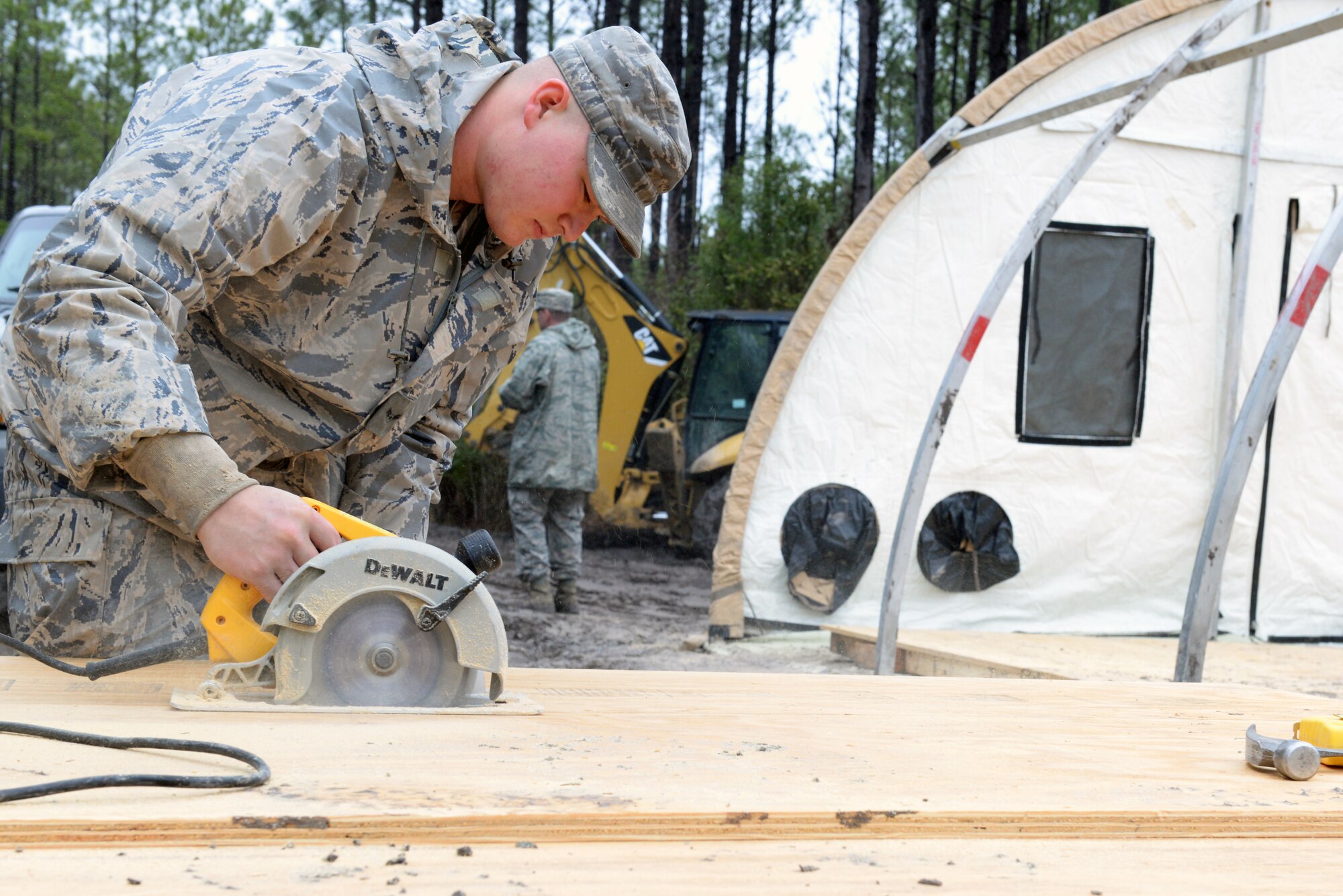 U.S. Air Force Airman 1st Class Thomas Reed, 23d Civil Engineer Squadron electrical power production journeyman, cuts a wooden plank Feb. 24, 2015, near Statenville, Ga.  The planks were used as a foundation for building a command post in response to a non-lethal aircraft accident involving an F/A-18D Hornet assigned to Marine Corps Air Station Beaufort, S.C. (U.S. Air Force photo by Airman Greg Nash/Released)