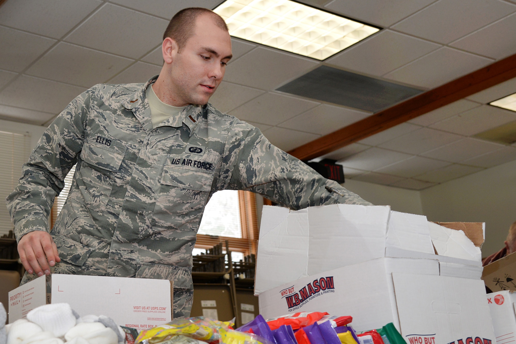 Second Lt. James C. Ellis, Battle Management Directorate, and more than 25 others, volunteer to build care packages during a Troop Care Drive at the base chapel March 4. Sponsored by the Company Grade Officer Council, volunteers packaged more than 200 boxes to send to deployed service members overseas. (U.S. Air Force photo by Linda LaBonte Britt)