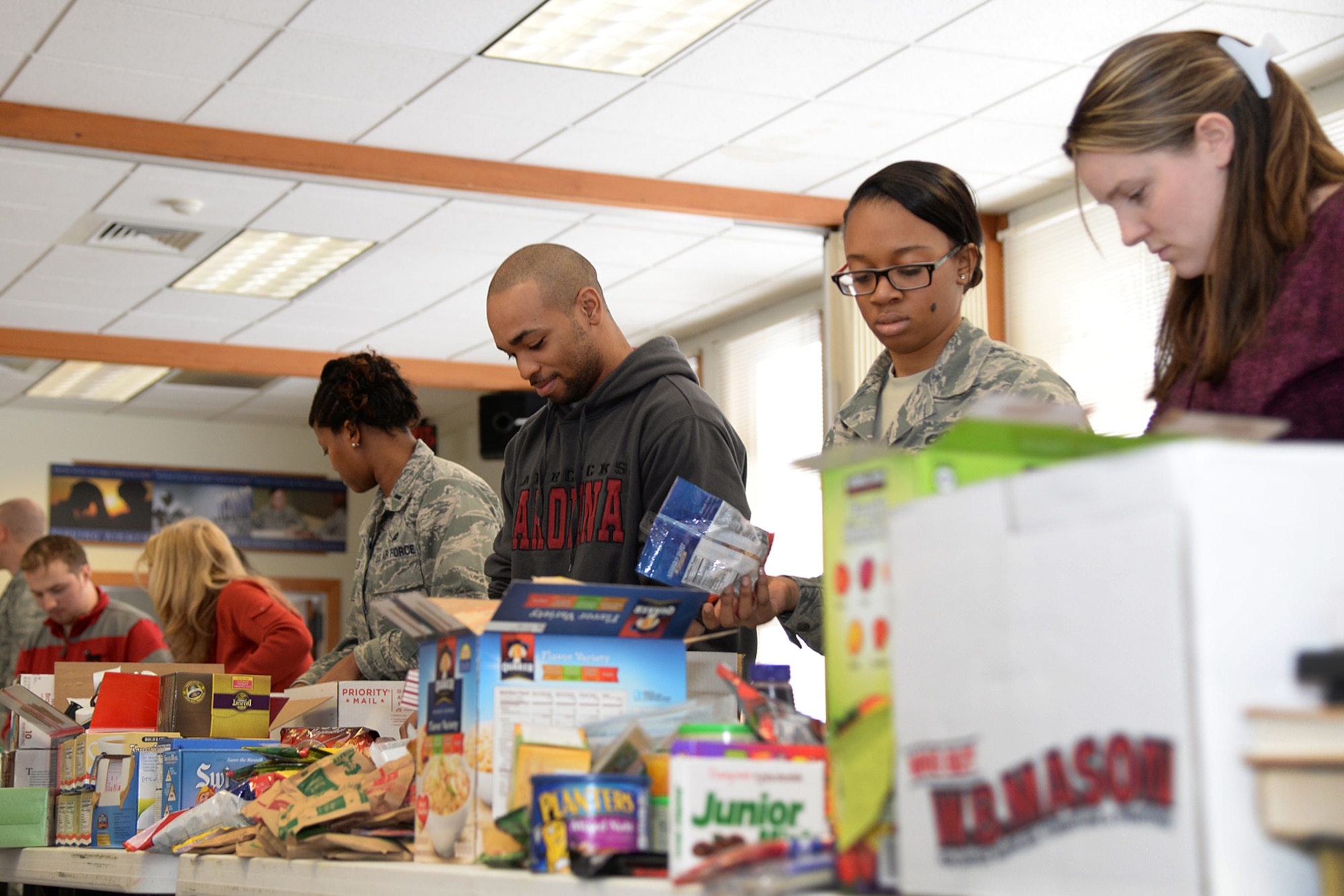 More than 25 volunteers work together to build care packages for deployed personnel during the quarterly Company Grade Officers Council sponsored Troop Care Drive at the base chapel March 4. Volunteers packed more than 200 care packages to mail to deployed service members. (U.S. Air Force photo by Linda LaBonte Britt)