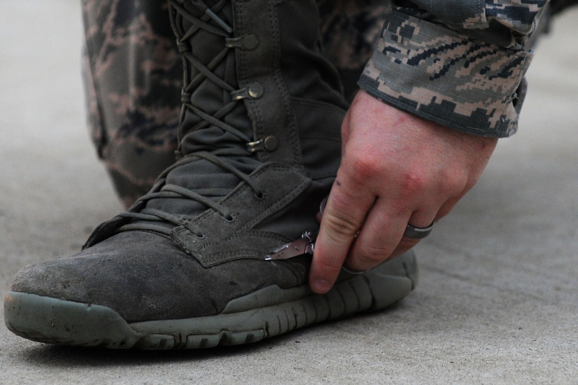 A U.S. Air Force Airman assigned to the Senior Master Sgt. David B. Reed Airman Leadership School Class 15-03 cuts a string of his boot before a uniform inspection at Shaw Air Force Base, S.C., March 5, 2015. ALS is an in depth leadership course designed to enhance Airmen’s leadership skills while expanding their overall Air Force knowledge. (U.S. Air Force photo by Airman 1st Class Michael Cossaboom/Released)