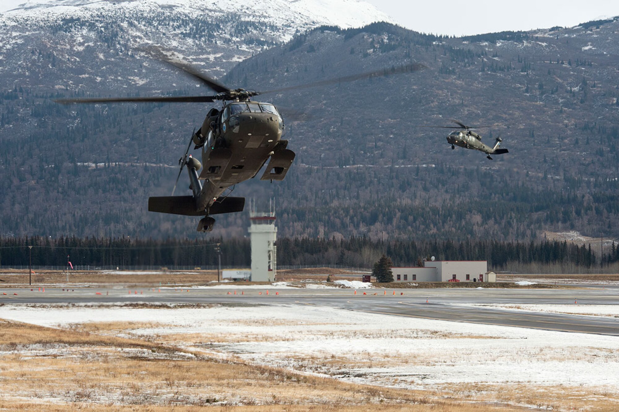 Two Alaska Army National Guard UH-60 Black Hawk helicopters assigned to 1st Battalion, 507th Aviation Regiment, approach a landing zone on Joint Base Elmendorf-Richardson, Alaska, Feb. 24, 2015. The Alaska Army National Guard participated in the Alaska Military Youth Academy outreach program to expose the cadets to military life. (U.S. Air Force photo/Alejandro Pena)