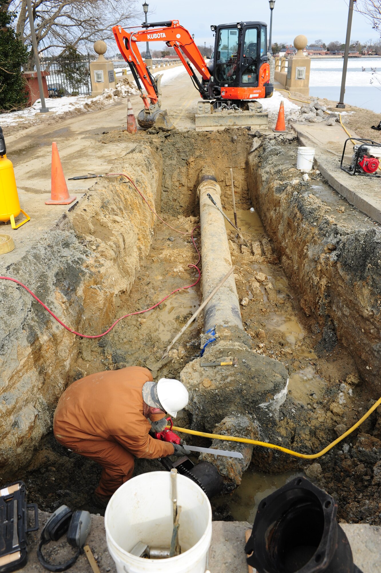 U.S. Air Force Senior Airman Anthony Boe, 633rd Civil Engineer Squadron water and fuel systems apprentice, prepares to a saw into a ductile iron water pipe Feb. 24, 2015, near the King Street gate at Langley Air Force Base, Va. A portion of the pipe was damaged during inclement weather when it burst, causing the King Street gate’s closure.(U.S. Air Force photo by Staff Sgt. Natasha Stannard/Released)
