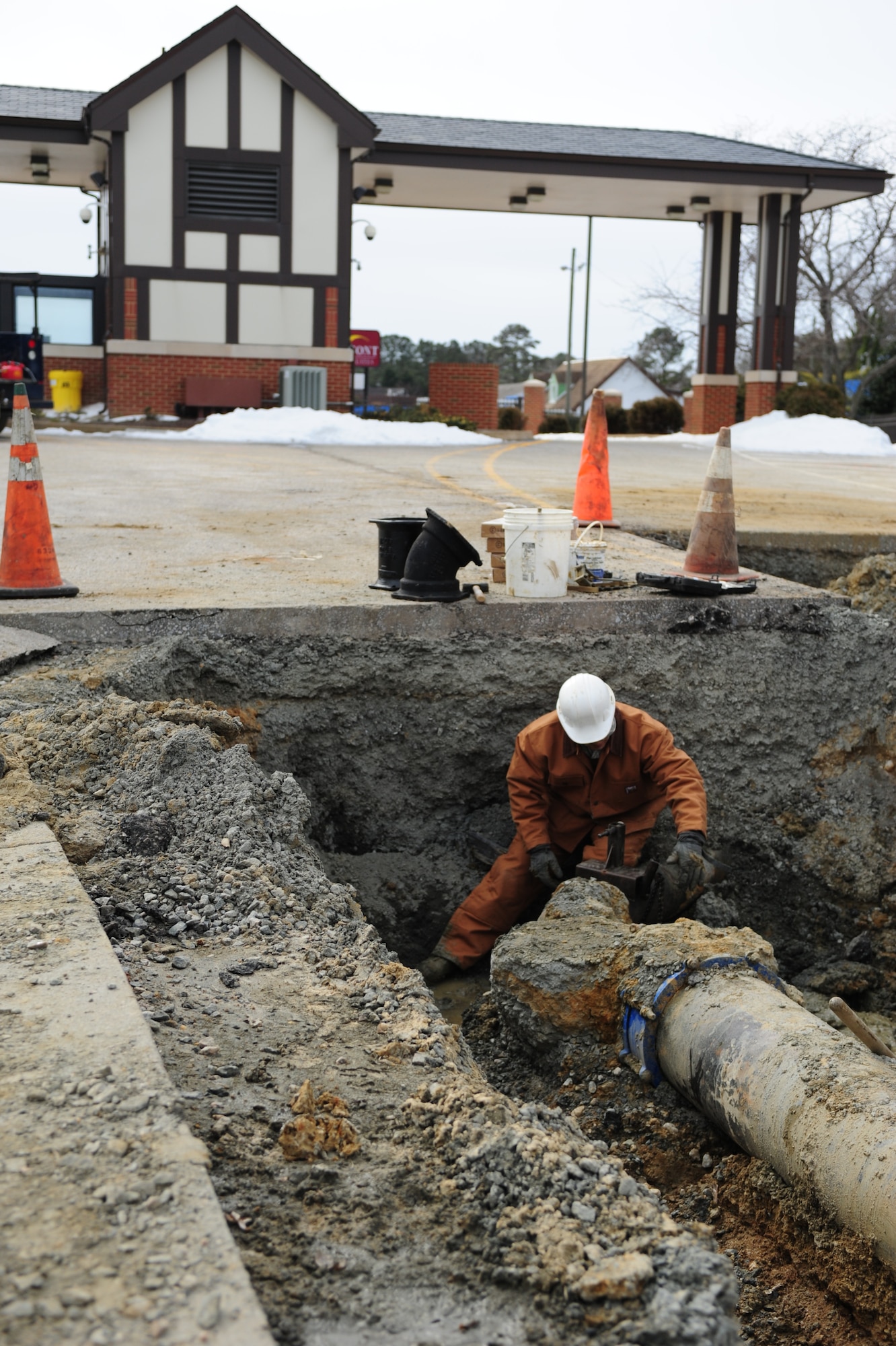 U.S. Air Force Senior Airman Anthony Boe, 633rd Civil Engineer Squadron water and fuel systems apprentice, connects a pipe clamp to make a cut to a ductile iron water pipeline Feb. 24, 2015, near the King Street gate at Langley Air Force Base, Va. The CES Airmen worked around the clock on many weather related projects throughout the base during inclement weather in February. (U.S. Air Force photo by Staff Sgt. Natasha Stannard/Released)