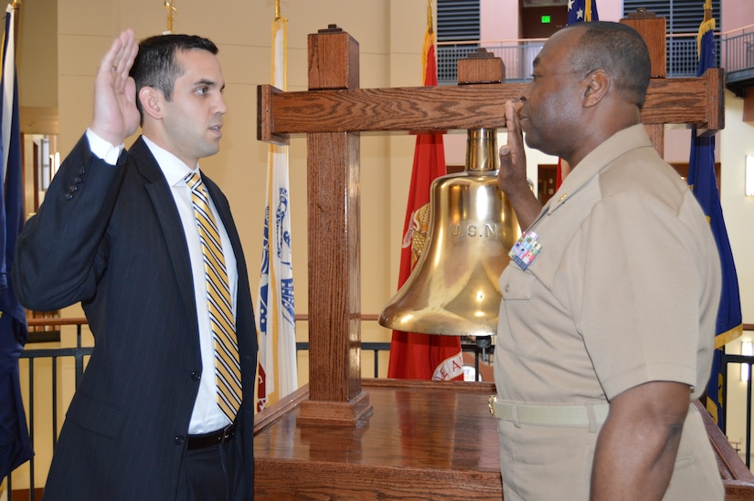 Naval Health Clinic Charleston Commanding Officer Marvin Jones, right, administers the Commissioning Oath to Lt. John McGinnis March 4, 2015 at NHCC on Joint Base Charleston, S.C. McGinnis, a recent graduate of the Medical University of South Carolina's
Doctor of Physical Therapy program, applied for and was accepted to the Navy Medical Service Corps while completing his last MUSC clinical rotation with NHCC's Physical Therapy department. McGinnis will begin five weeks of military orientation training at the Naval Officer Development School this Spring. (Navy photo/Kris Patterson)
