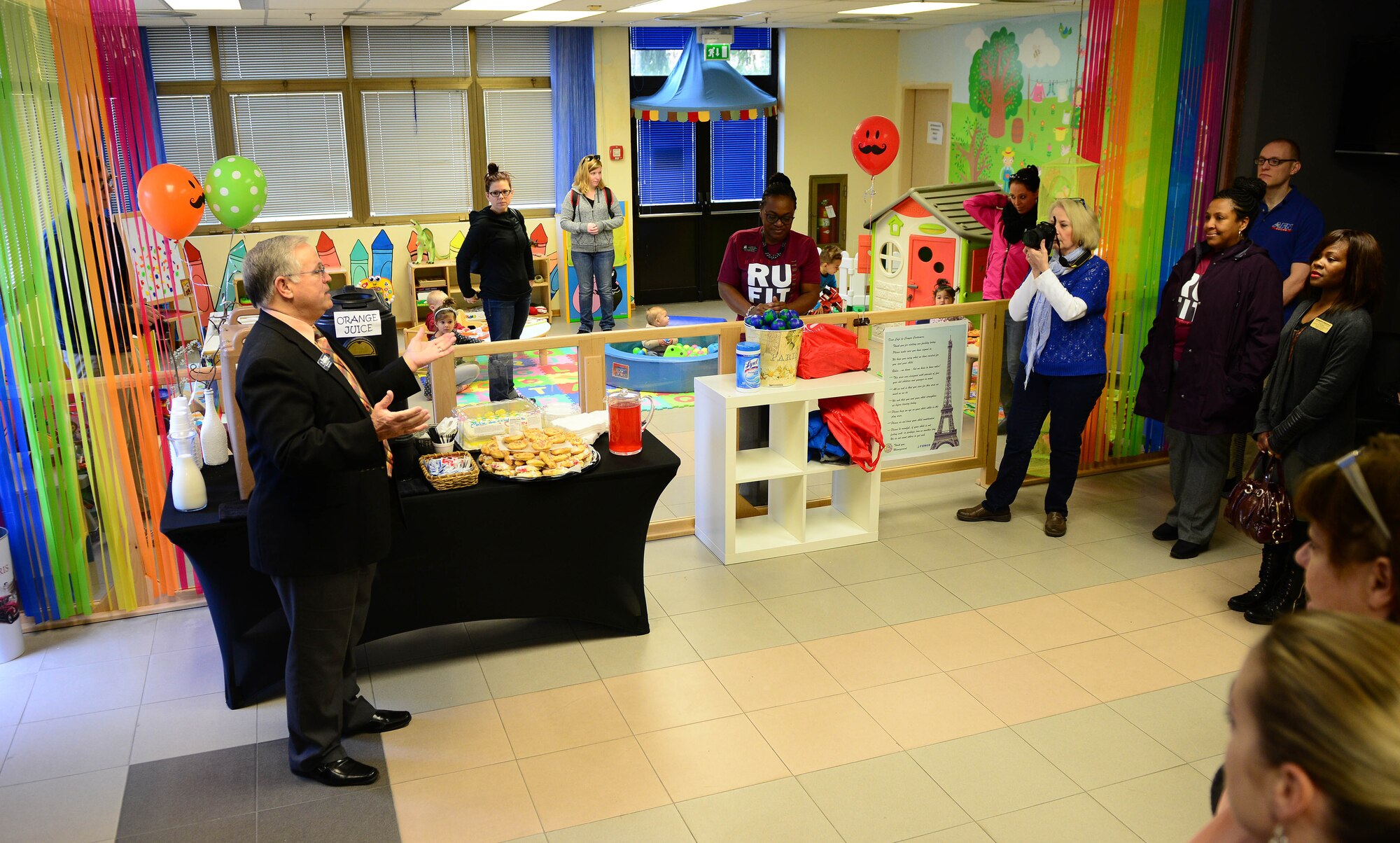 Donald Cook, 31st Force Support Squadron deputy director, speaks during the grand opening of Café de Crayons, March 5, 2015, at Aviano Air Base, Italy. Café de Crayon, a new room inside the Aviano Community Center, gives children a safe environment to play while parents enjoy time with other spouses. (U.S. Air Force photo by Senior Airman Matthew Lotz/Released)