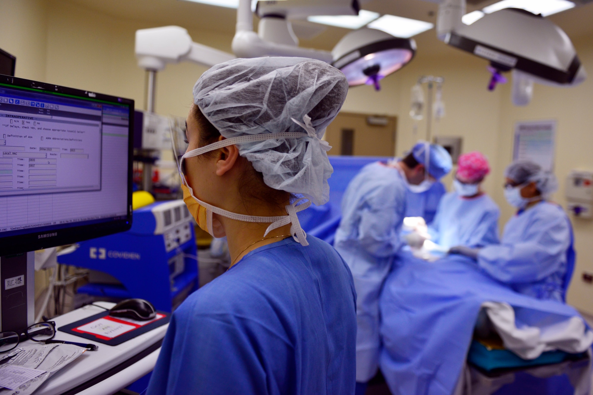 U.S. Air Force Maj. Alisa Paige, 31st Surgical Operations Squadron operating room nurse, charts patient information, during a surgery, March 4, 2015, at Aviano Air Base, Italy. An OR nurse is responsible for providing professional nursing care to patients undergoing surgery and conduct post and preoperative visits with patients. (U.S. Air Force photo by Airman 1st Class Ryan Conroy/Released) 