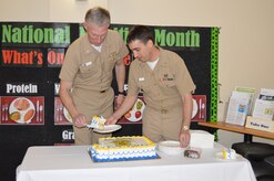 Captain Edward Butler, left, dermatologist for Naval Health Clinic Charleston, and Lt. Joseph Siegel, an NHCC physician, cut the cake during a celebration in honor of the 144th birthday of the ‪Navy Medical Corps‬ March 3, 2015 in the NHCC atrium at Joint Base Charleston, S.C. The Navy Medical Corps was March 3, 1871. (U.S. Navy / Kris Patterson) 