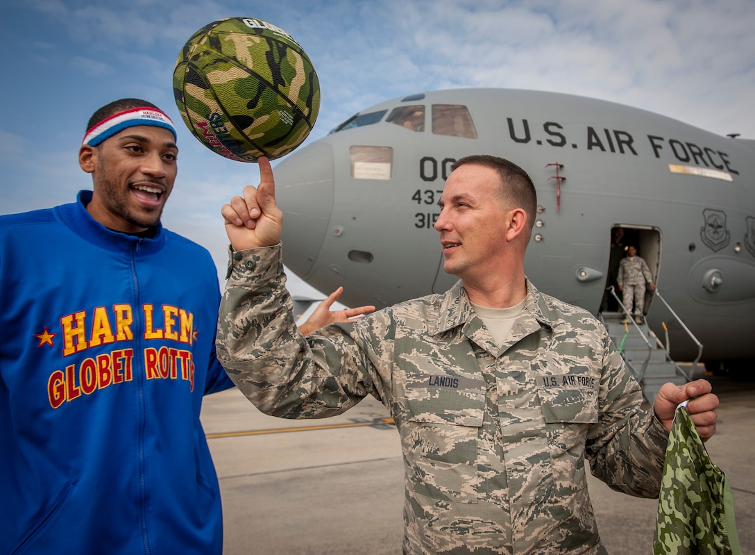 Tech. Sgt. Jeffrey Landis, 315th Maintenance Squadron, spins a basketball on his finger tip with Harlem Globetrotter "Zeus" McClurkin outside a C-17 Globemaster III earlier this week.  Landis was selected as the Globetrotters' Hometown Hero for their March 10 game in North Charleston, S.C..  (U.S. Air Force Photo by Senior Airman Thomas Brading)
