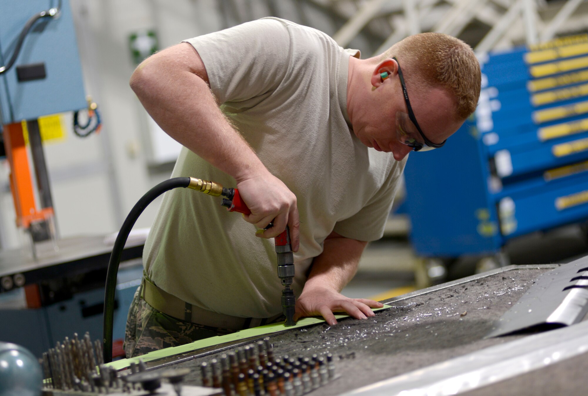 U.S. Air Force Tech. Sgt. Jeremy Ryan, 31st Maintenance Squadron aircraft structural maintenance craftsman, drills holes into an F-16 Fighting Falcon flap panel, March 4, 2015 at Aviano Air Base, Italy. Aircraft structural maintenance Airmen manufacture hydraulic, fuel and air lines for all aircraft. (U.S. Air Force photo by Senior Airman Areca T. Wilson/Released)