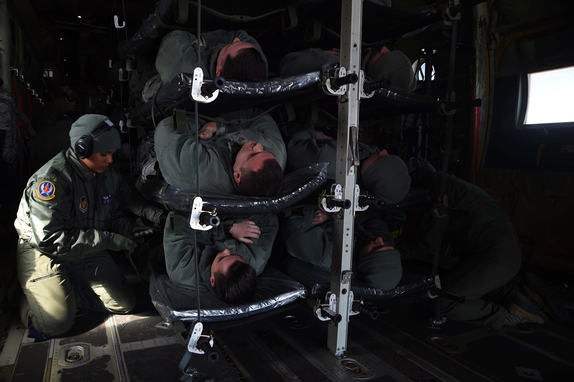 Capt. Sarah Green, 18th Aeromedical Evacuation Squadron, prepares 35th Fighter Wing Airmen posing as patients during an aeromedical evacuation exercise at Misawa Air Base, Japan, March 5, 2015. The 18 AES transported the Misawa Airmen by C-130J Hercules from the Republic of Korea where they carried out operational readiness exercise scenarios as part Beverly Sunrise 15-2. After arriving at Misawa, the patients were secured to litters before being moved to the base hospital for care. (U.S. Air Force photo by Staff Sgt. Alyssa C. Wallace/Released)