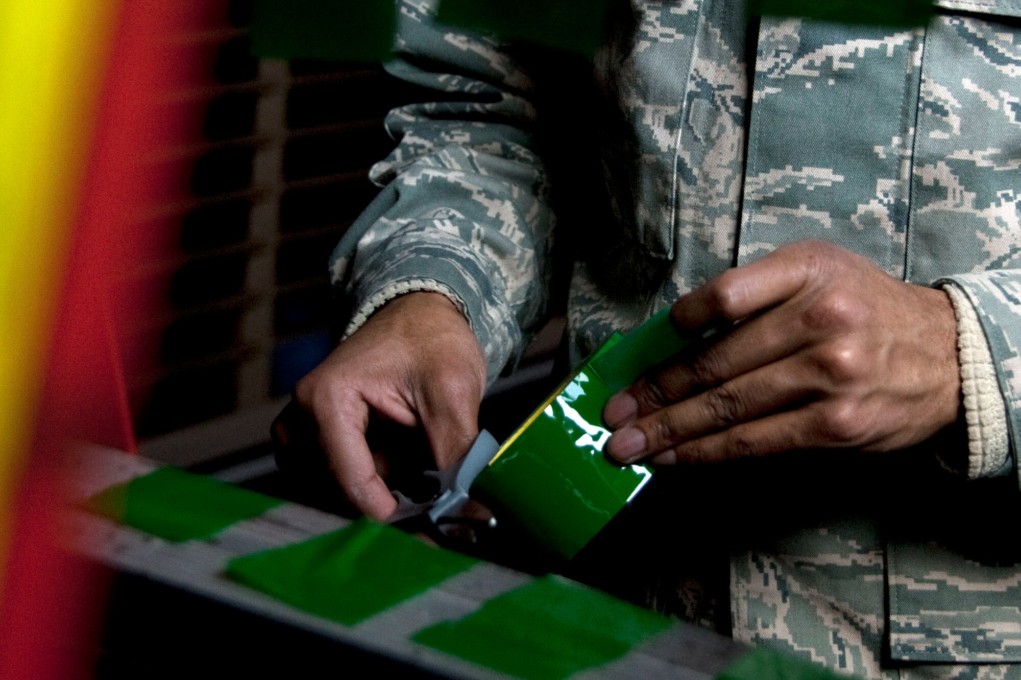 U.S. Air Force Senior Airman David Mathews, a 51st Force Support Squadron (FSS) outbound assignment counselor, prepares tape to black out windows March 1, 2015, in the Osan Air Base, Republic of Korea, Fitness and Sports Complex as part of the bed down team during exercise Key Resolve. Bed down is the process during contingency operations where FSS facilitates lodging accommodations in gymnasiums and tents. (U.S. Air Force photo by Staff Sgt. William Banton/Released)