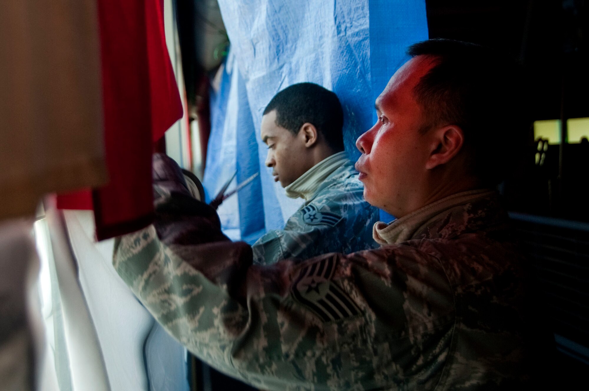 U.S. Air Force Staff Sgt. Apichet Worawattana and Senior Airman David Mathews, 51st Force Support Squadron (FSS) outbound assignments counselors, prepare to black out windows March 1, 2015, in the Osan Air Base, Republic of Korea, Fitness and Sports Complex as part of the bed down team during exercise Key Resolve. Bed down is the process during contingency operations where FSS facilitates lodging accommodations in gymnasiums and tents. (U.S. Air Force photo by Staff Sgt. William Banton/Released)