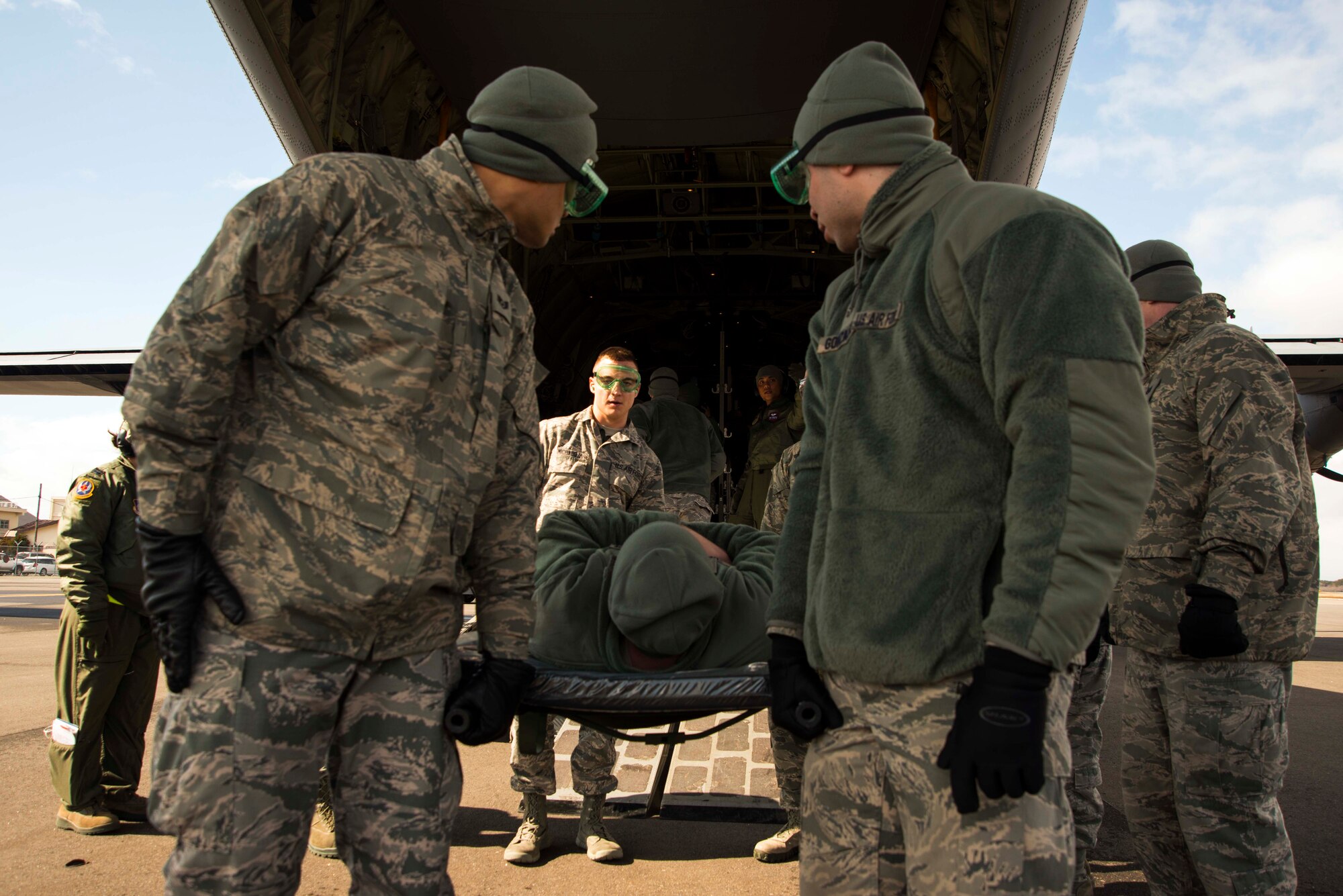 Airmen from the 35th Medical Group transport a patient from a C-130 Hercules during an aeromedical evacuation exercise March 5, 2015, at Misawa Air Base, Japan. The 35 MDG transported about 30 patients to the base hospital in support of an operational readiness exercise that ran through the week. The California Air National Guard supplied the C-130s used to deploy and transport patients. (U.S. Air Force photo by Staff Sgt. Derek VanHorn/Released)