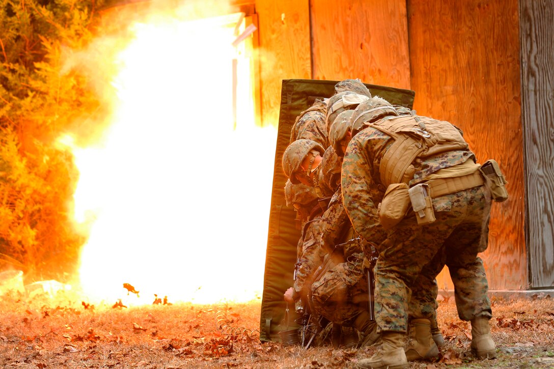 Marines take cover behind a blast blanket as detonation cord ignites, blowing a door in and giving the Marines a clear passage to breach a building during an urban breaching course on Camp Lejeune, N.C., March 3, 2015.