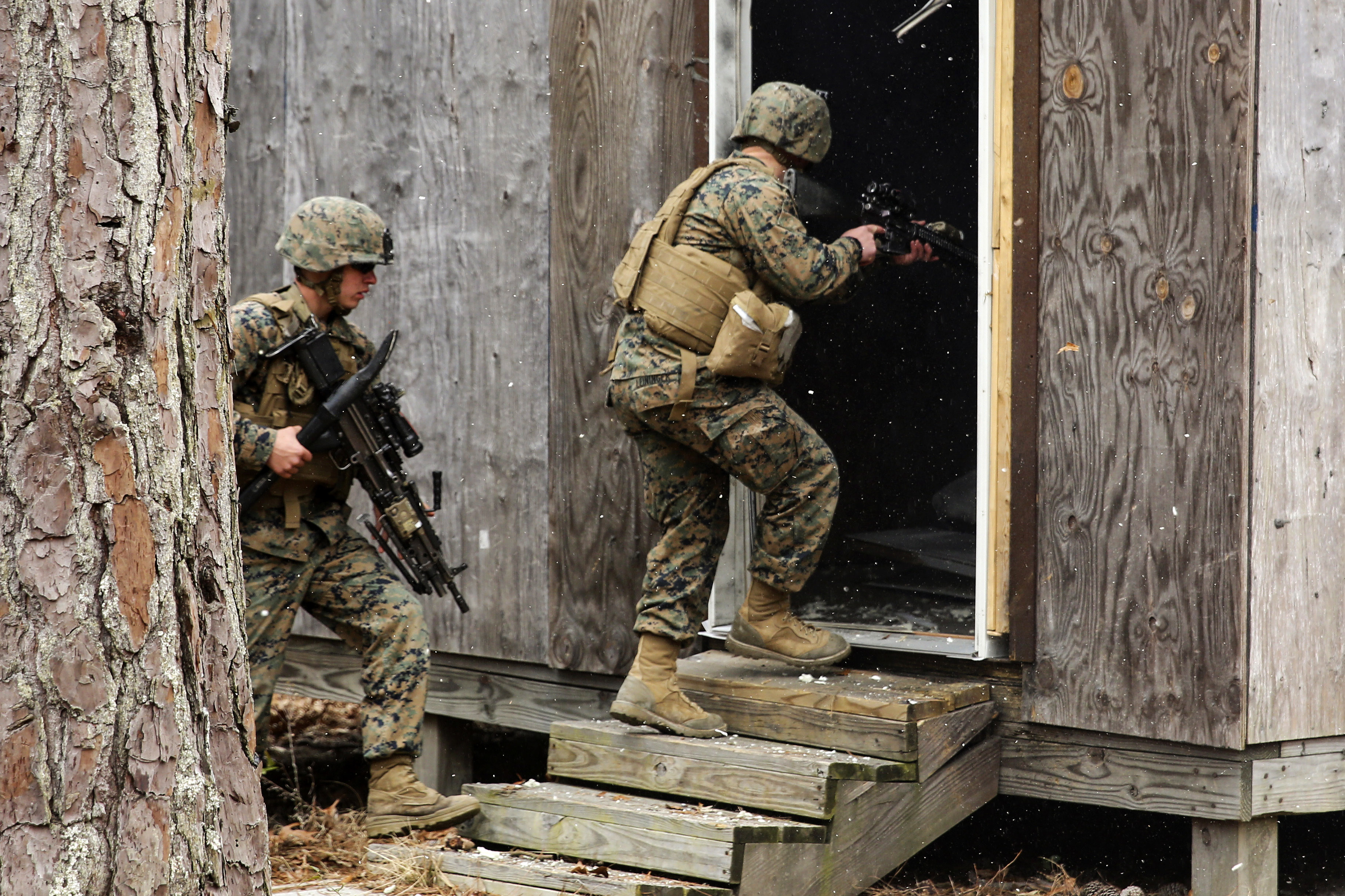 Marines enter a building after blowing the door off its hinges using